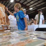 Blythe Godfrey, 11, adds her mark to an oil painting by Iwona Barlyska during the 153rd annual Chilliwack Fair at Chilliwack Heritage Park on Saturday, Aug. 9, 2025.