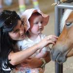 Shannon Brogan and 20-month old daughter Sadie of Vancouver meet a pony during the 153rd annual Chilliwack Fair at Chilliwack Heritage Park on Saturday, Aug. 9, 2025.