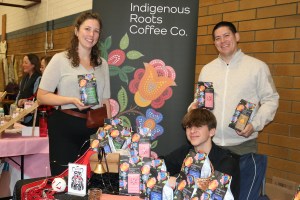 Co-founders of Indigenous Roots Coffee Company Natasha Parrish (Sk'ing lúudas) and Kear Porttris, with nephew Joshua Josok, showcase products at the Oaklands West Coast winter market.
