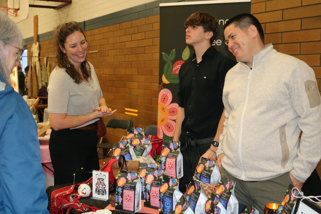 Co-founders of Indigenous Roots Coffee Company Natasha Parrish (Sk'ing lúudas) and Kear Porttris, with nephew Joshua Josok, showcase products at the Oaklands West Coast winter market.