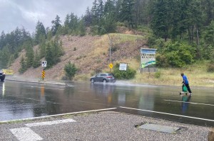 A man on a skateboard cruises across Highway 97 at Crystal Waters Road Wednesday, July 9, narrowly getting hit by vehicles.