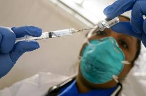A physician extracts COVID-19 vaccine from a vial. (AP Photo/Mary Altaffer, File)