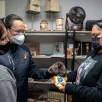 Tammy Brown (left), Lorisha Desjarlais (centre left) and Teneshia Yahey (right) admire one of the moccasins available at the CWAA Market.