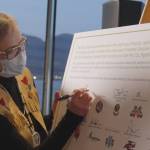 Chief Corrina Leween, Cheslatta Carrier Nation, signs commemoration document.