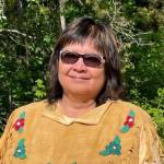 Bonnie George wears a shawl gifted to her by her mother. To Bonnie, this shawl represents the strength and resilience of her people.