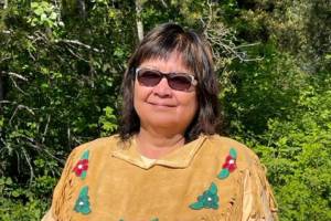 Bonnie George wears a shawl gifted to her by her mother. To Bonnie, this shawl represents the strength and resilience of her people.