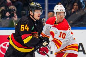 Vancouver Canucks forward David Kampf, left, battled with Calgary Flames forward Jonathan Huberdeau during NHL action Sunday, Nov 23, 2025 at Rogers Arena in Vancouver. (https://x.com/Canucks photo)