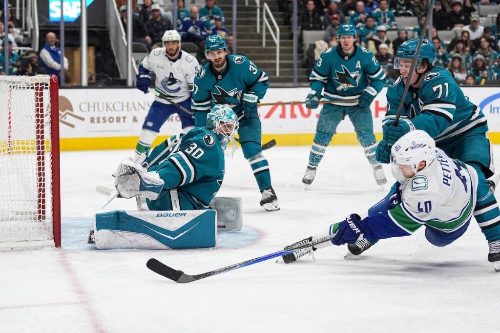Vancouver Canucks forward Elias Pettersson (40), scores while falling down against San Jose Sharks goalie Yaroslav Askarov during NHL action Friday, Nov. 28, 2025 at the SAP Center in San Jose, Calif.