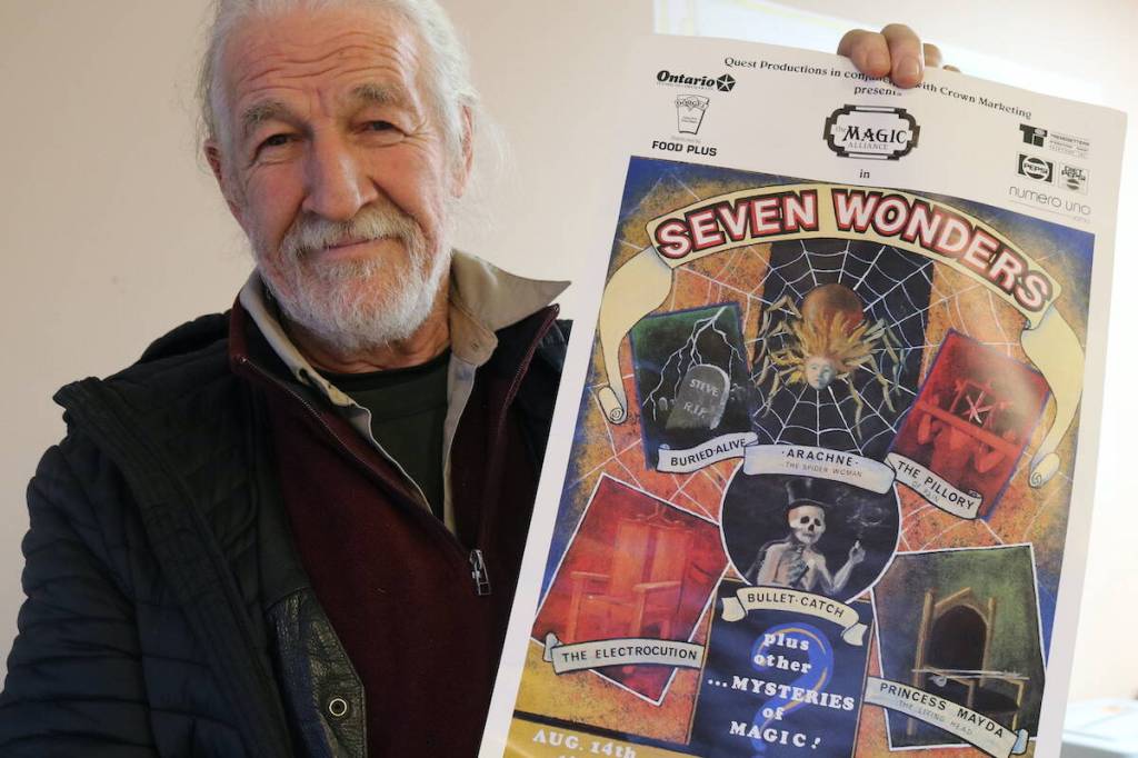 Guy Simmons with a 1991 poster advertising the Magic Alliance in Seven Wonders. (Ben Fenlon/Sooke News Mirror)