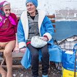 Two seniors rest on a bench after being relocated from the front in eastern Ukraine. (Photo by Darrell McKay)