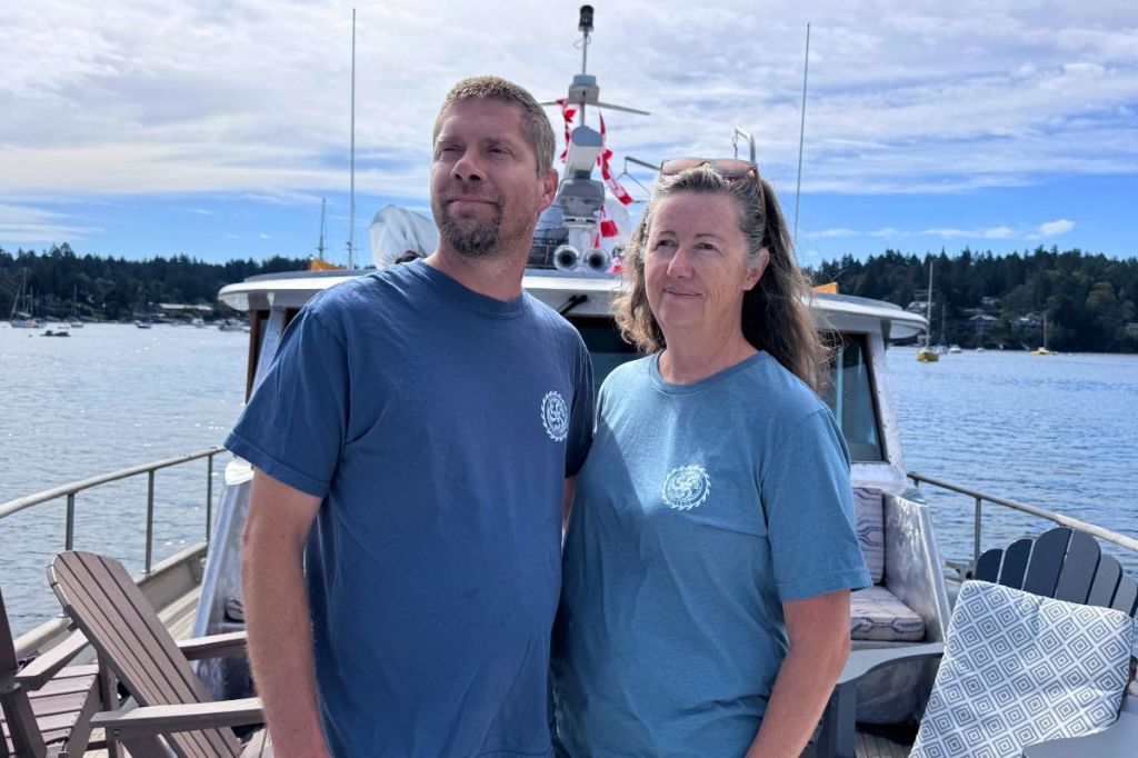 Blaine and Janis Carmena on the bow of their boat, Tangaroa.