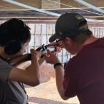A boy with an NSRG coach making sure the Snider rifle is armed and ready.