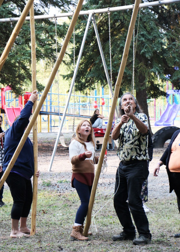 Avery Finlayson watches as Tony Solomon tugs on a tope to secure some teepee poles together at Horse Lake Elementary School. (Patrick Davies photo - 100 Mile Free Press)