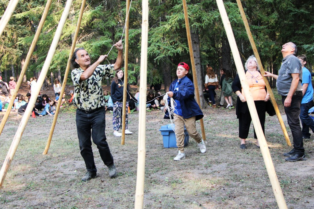 Tony Solomon and Shane Mikkelsen work together to build a teepee at Horse Lake Elementary School. (Patrick Davies photo - 100 Mile Free Press)