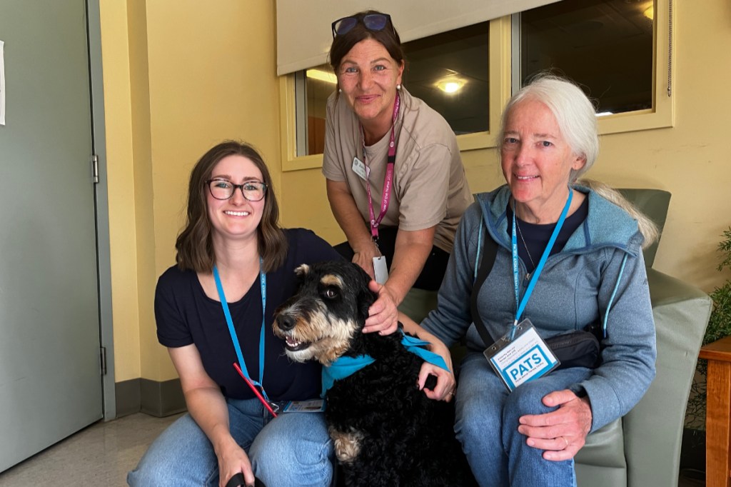 PATS handler Celine Foucher, nurse Kirsten Lambohs and Kimberley Nemrava, placements coordinator for PATS, stop for a photo at Victoria Hospice.