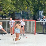 Girls play street hockey in a new Big Backyard "free play zone" at the PNE fair site in Vancouver on Aug. 14. 2025.