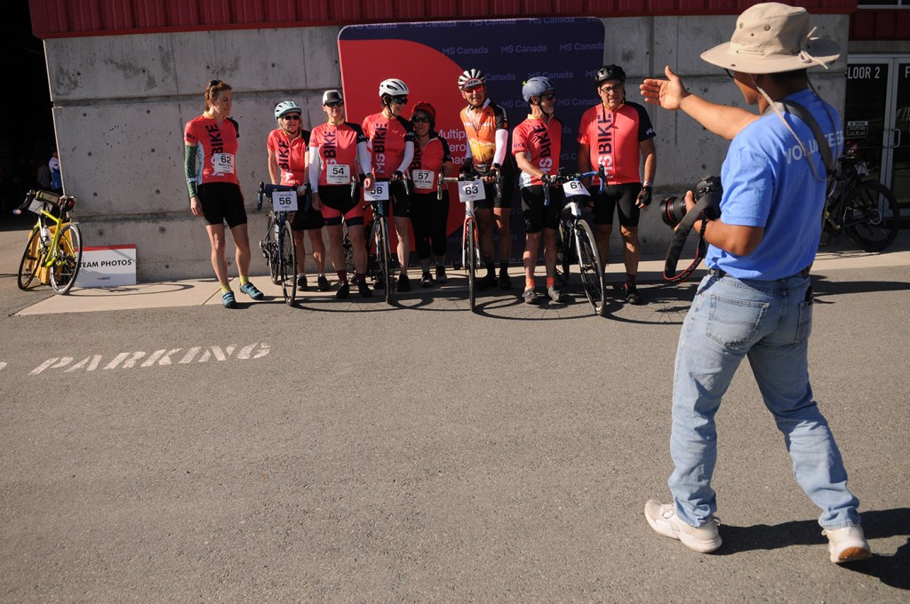 A volunteer photographer positions people for a photo during the MS Bike Chilliwack fundraiser for multiple sclerosis at Chilliwack Heritage Park on Saturday, July 12, 2025.