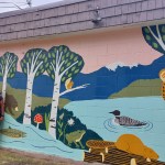 Robi McKnight (left) and Andrea Callison check out the new mural on the pump house while  enjoying a picnic at Riverside Municipal Park. (Sonja Lester)