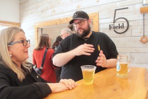 Chris Bjerrisgaard of Small Gods Brewing chats with MLA Lana Popham as he and the minster of agriculture and food enjoy a Peninsula Lager at Field Five in Central Saanich earlier this year.