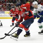 Washington Capitals left wing Alex Ovechkin skates with the puck past Vancouver Canucks defenceman Vincent Desharnais (73) during the first period of an NHL hockey game, Wednesday, Jan. 8, 2025, in Washington. (AP Photo/Nick Wass)