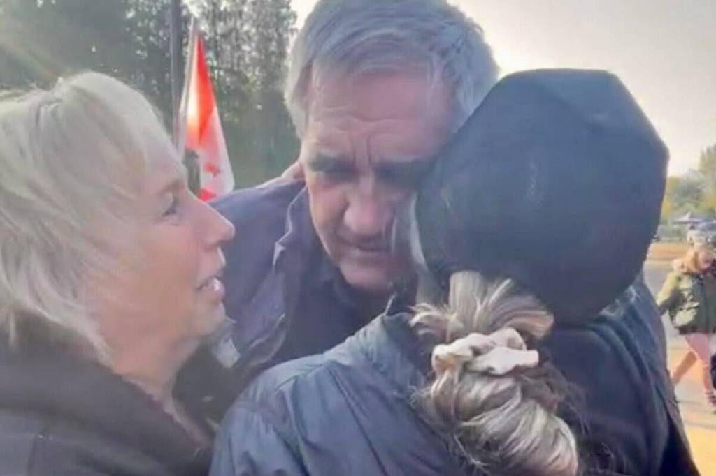 Karen Espersen (left), Dave Bilinski and Katie Pasitney share a hug over the news that stay order on the cull of the ostriches was granted Sept. 24.