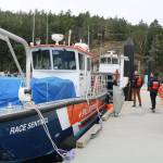 Senior manager of communications Michael Lowry and operations base manager Kyle Hujdic walk between spill response vessels docked at Beecher Bay. (Ben Fenlon/Sooke News Mirror)
