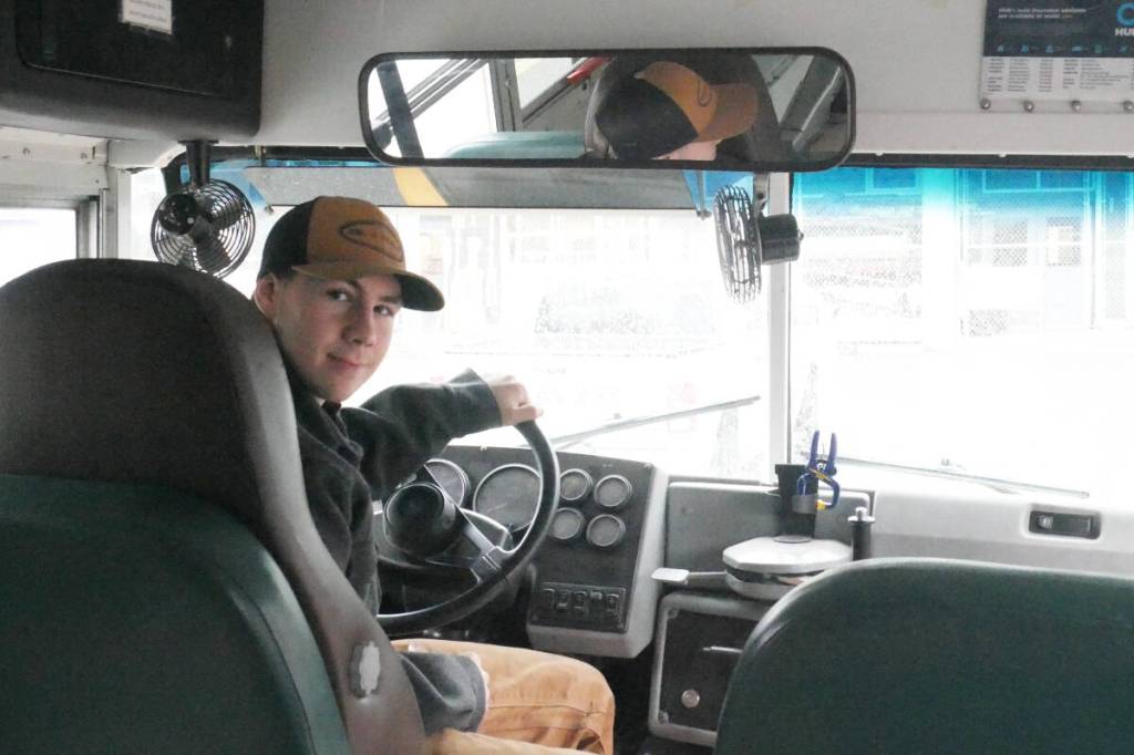 Turi Duhamel, 17, with the School District 19 bus he bought and is converting into a camper and workshop for his Revelstoke Secondary School capstone project, pictured Wednesday, Oct. 29. (Evert Lindquist/Revelstoke Review)