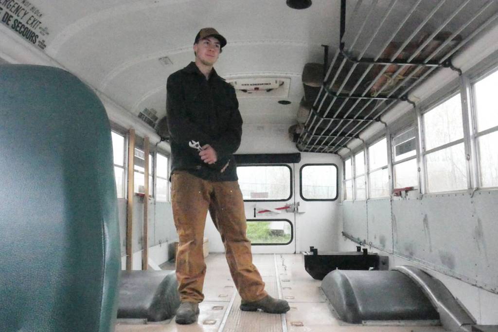 Turi Duhamel, 17, with the School District 19 bus he bought and is converting into a camper and workshop for his Revelstoke Secondary School capstone project, pictured Wednesday, Oct. 29. (Evert Lindquist/Revelstoke Review)
