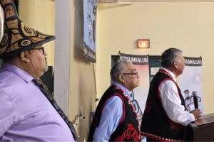 Kitsumkalum Chief Negotiator Gerald Wesley (at podium) addresses the Nation while Chief Negotiator Alex Bolton (middle) and Chief Councillor Troy Sam look on during the Treaty and Constitution ratification event on Nov. 1, 2025. (Kitsumkalum)